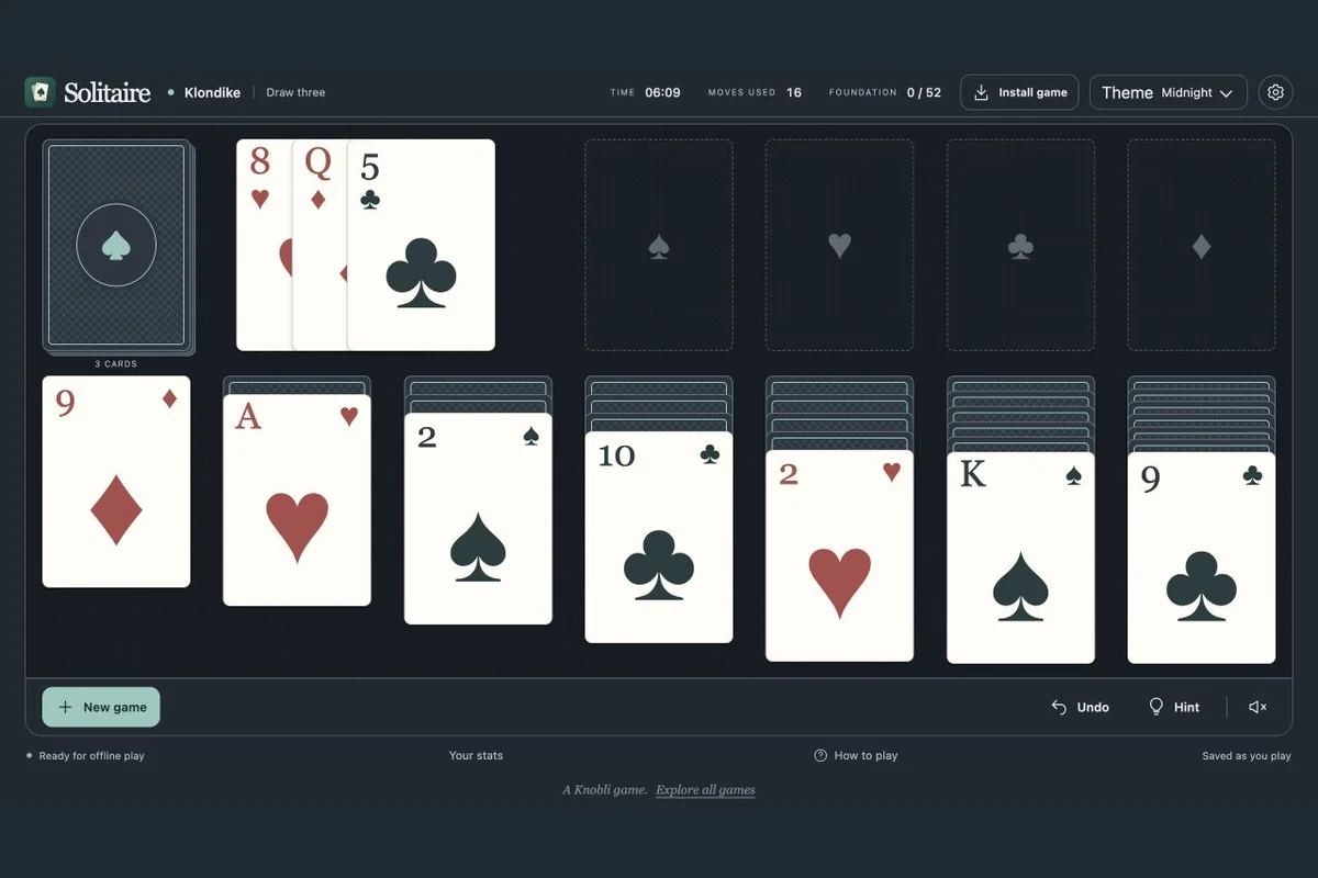 A Klondike solitaire game with seven columns of cards on a dark playing table.